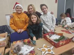 Wolontariusze pomagający tworzyć ozdoby świąteczne.