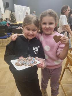 Dziewczynki pokazujące samodzielnie ozdobione pierniki.